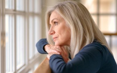 Older Caucasian woman looking out the window. Are you wondering if online depression treatment in Washington is right for your SAD? Learn more from a depression therapist in Seattle, WA