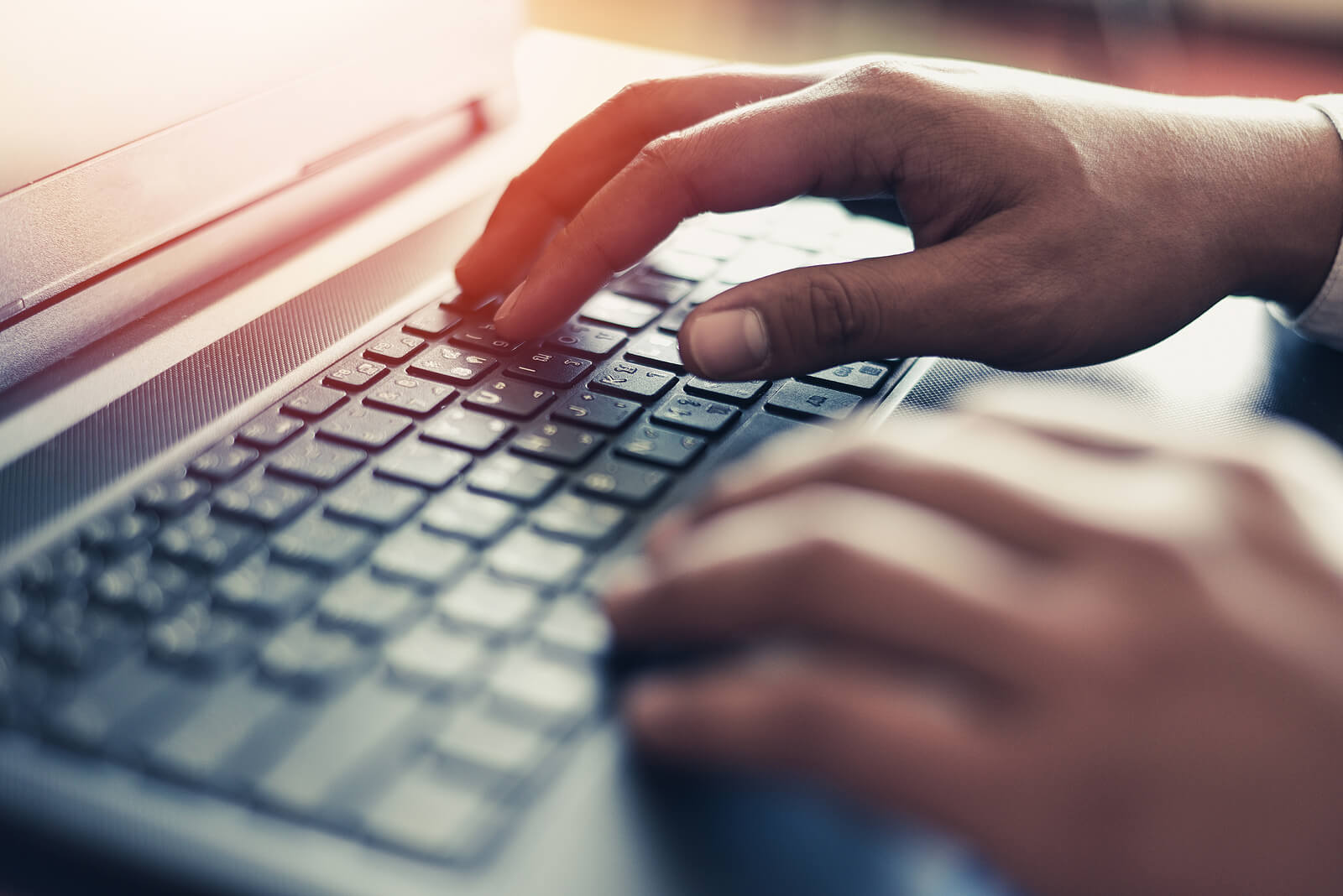 A close up of hands typing on a laptop keyboard. This could represent the search an online therapist in Seattle, WA. We offer support via online therapy in Seattle, WA and other services including online LBGTQ therapy in Seattle, WA.