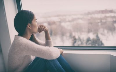 A woman sits looking out a wintery window with a pensive look. Learn how EMDR therapy in Seattle, WA can offer support from the comfort of home. Contact an EMDR therapist in Seattle, WA to learn more about the benefits of online EMDR therapy today!