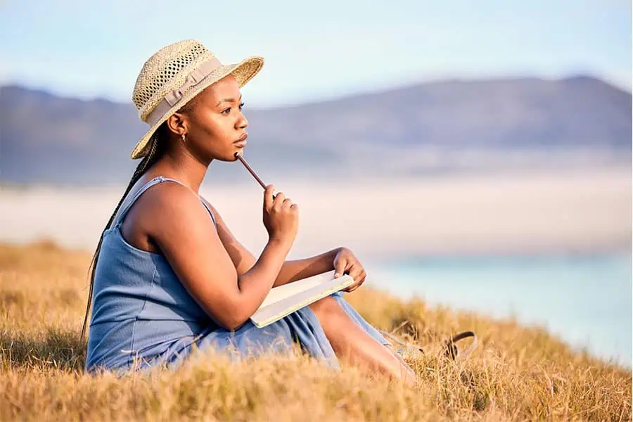 Shows a woman sitting and writing in a journal. Represents how online therapy in washington can support you through IFS.