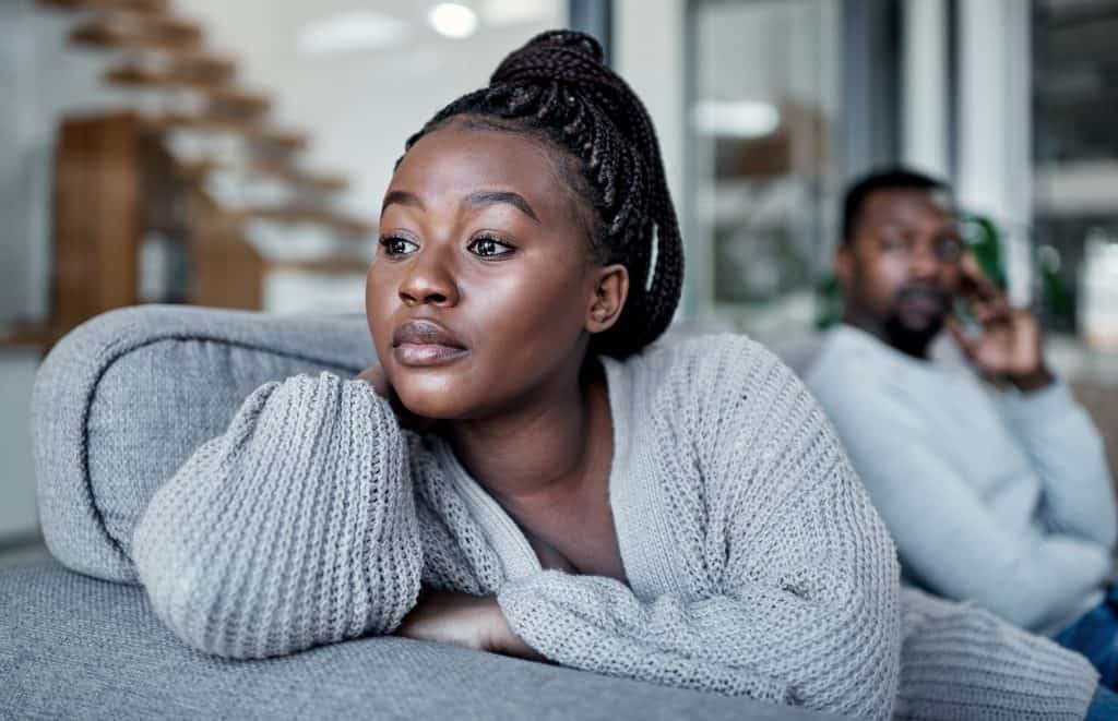A woman struggling with self-trust after having an argument on the sofa at home