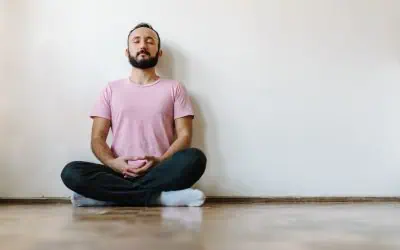 Person sitting crossed legged meditating with their eyes closed.
