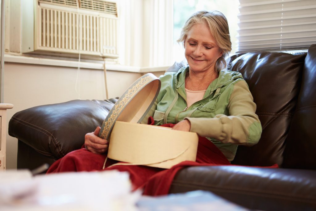 Woman going through grief opening care package from a friend 